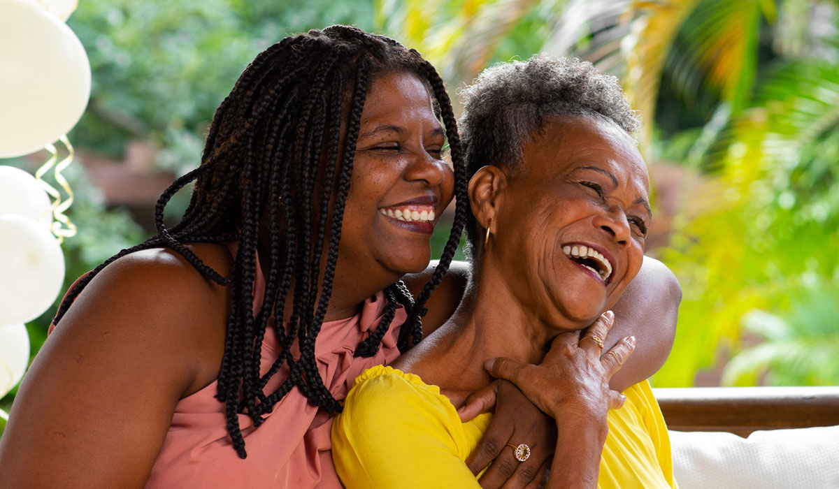 Femmes souriant en se tenant dans les bras